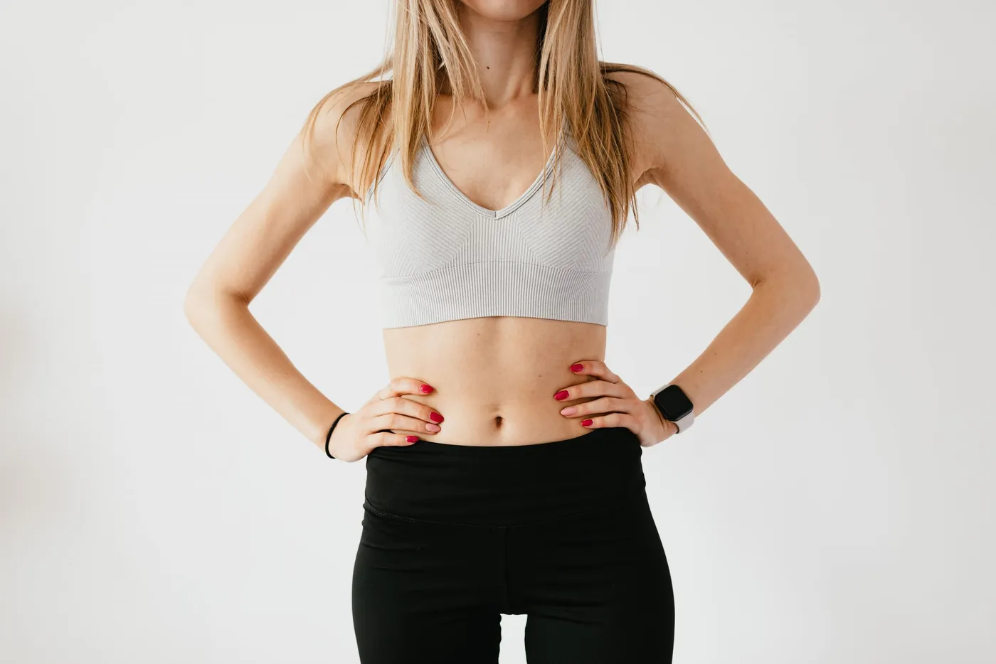 Woman in activewear with a contoured midsection after body treatment
